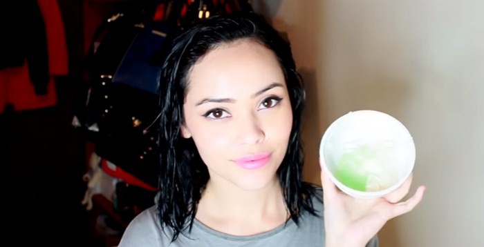 Foto de una chica con el cabello mojado y un recipiente blanco en la mano