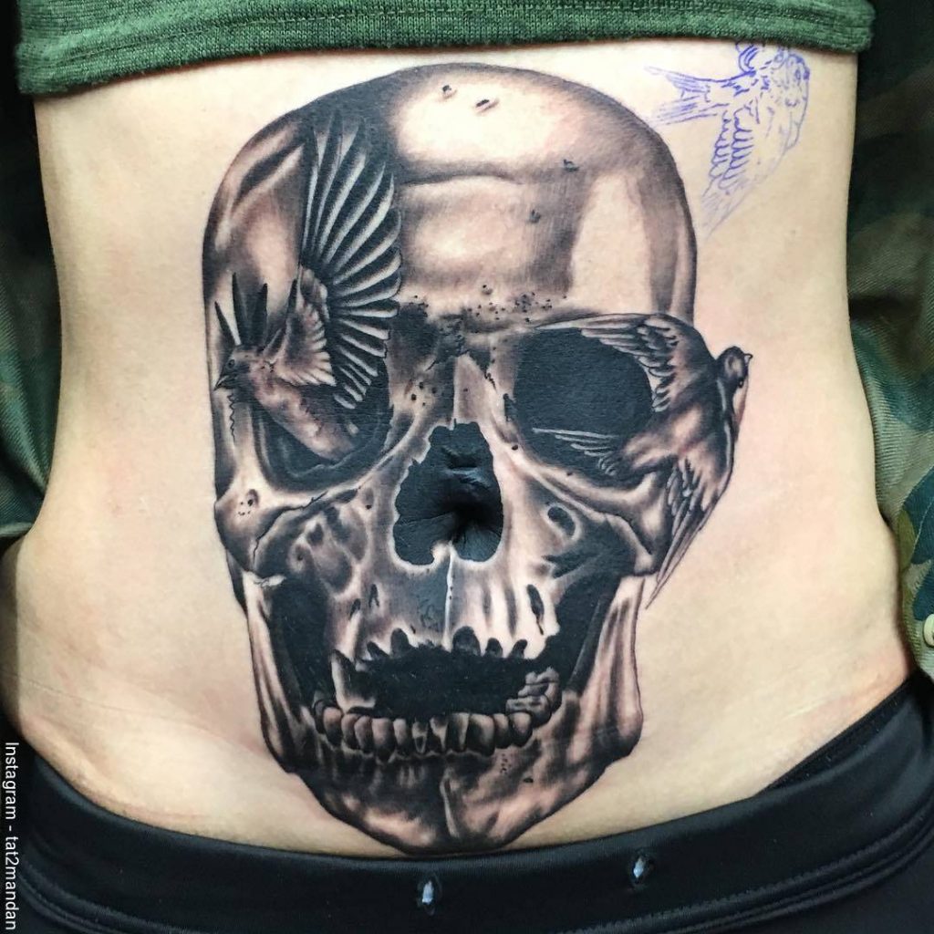 Foto de un tatuaje en el ombligo con una calavera