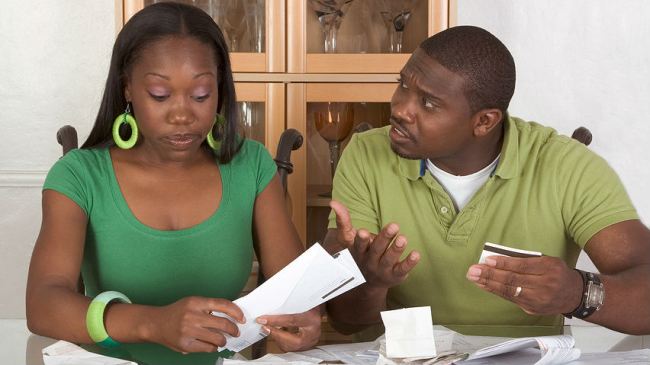 an black couple arguing about credit card purchases