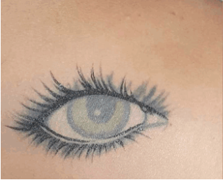 Tatuaje en la espalda de Marbelle en forma de ojo antes del retoque