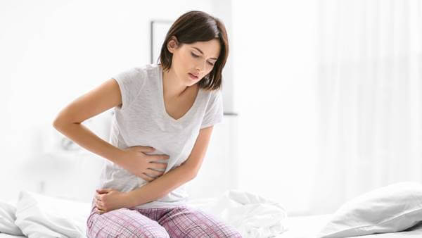 Foto de una mujer con dolor de estómago