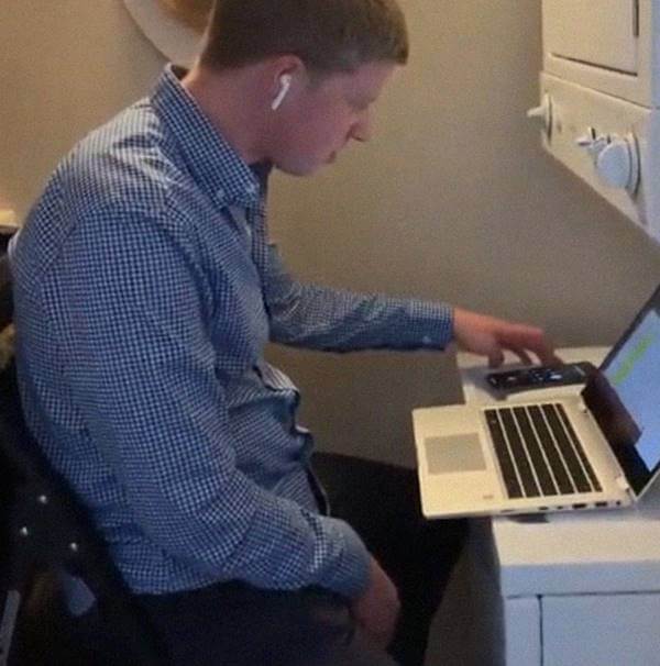 Foto de un joven trabajando y tiene el computador sobre una lavadora
