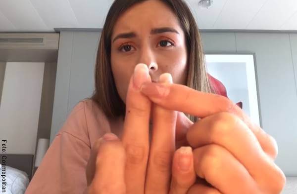 Foto de una chica mostrando sus uñas a la cámara