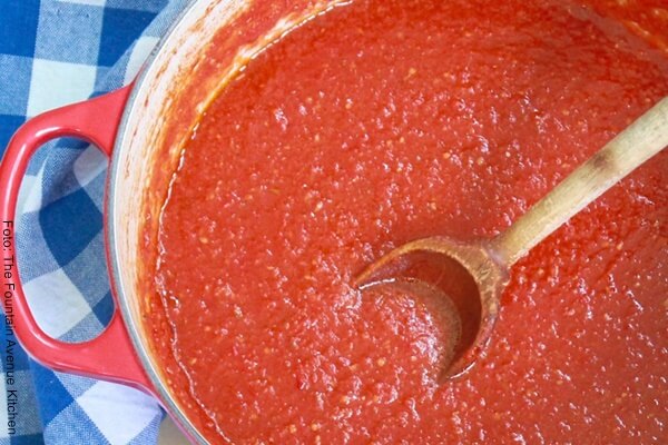 Foto de salsa roja con una cuchara pequeña de palo