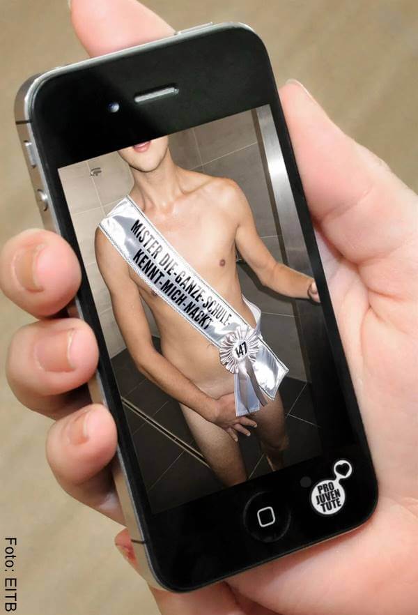 Foto de un celular en cuya pantalla aparece un hombre desnudo cubierto por una cinta de reina