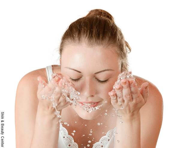 Foto de una chica lavando su rostro con agua