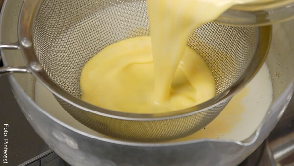 Foto de una mezcla de yemas de huevo y leche en un colador