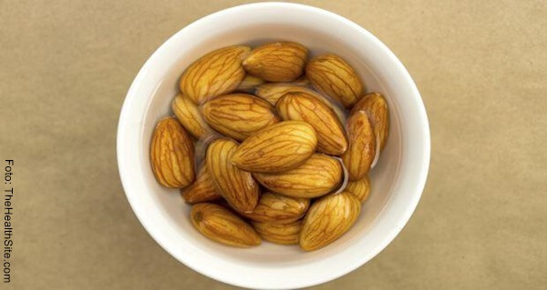 Foto de almendras remojadas en agua en un recipiente color blanco
