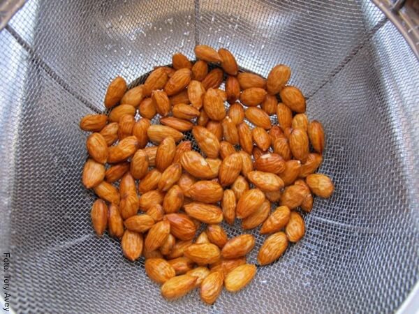 Foto de algunas almendras en un colador metálico