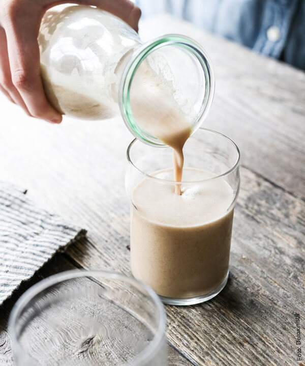 Foto de un vaso de vidrio con leche de almendras