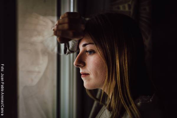 Foto de una mujer mirando por una ventana