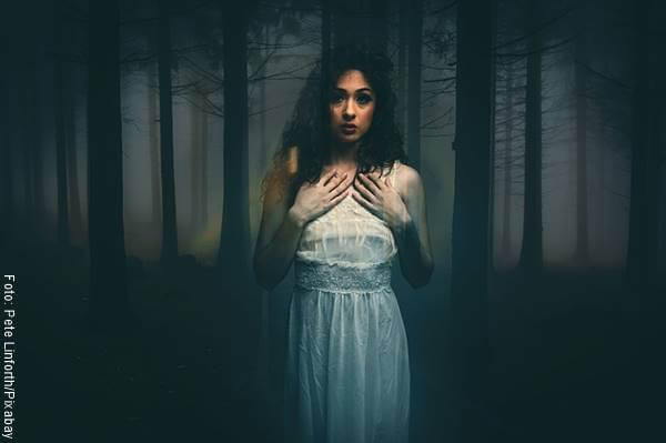 Foto de una mujer asustada en el bosque