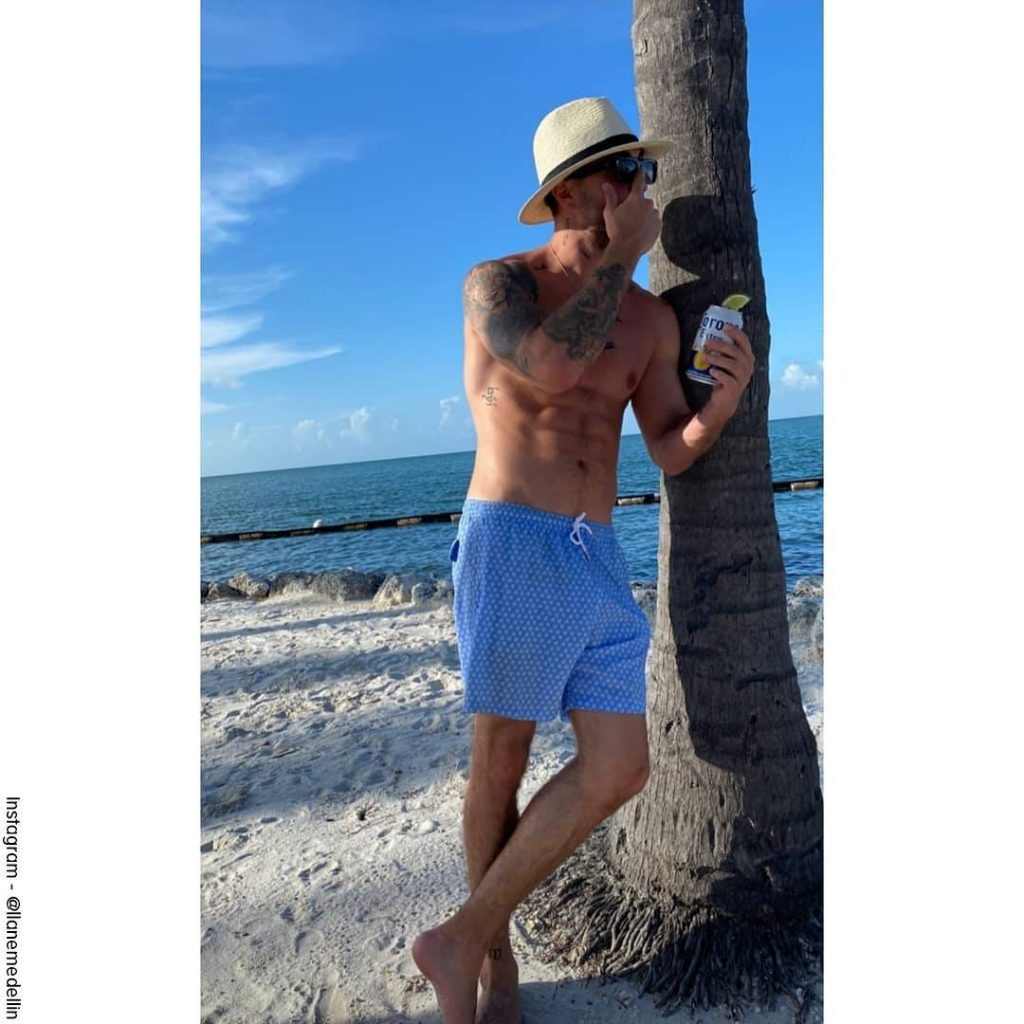 Foto de Llane en la playa con su pantaloneta azul y se le nota su paquete
