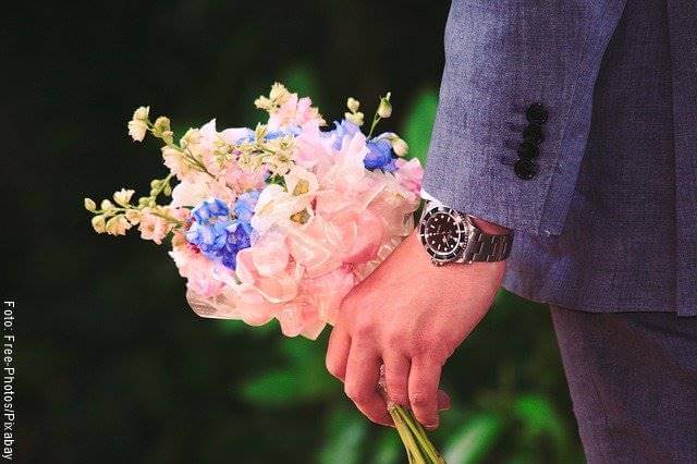 Foto de un hombre con un ramo de flores en la mano