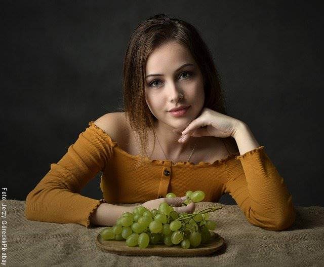 Foto de una mujer comiendo uvas