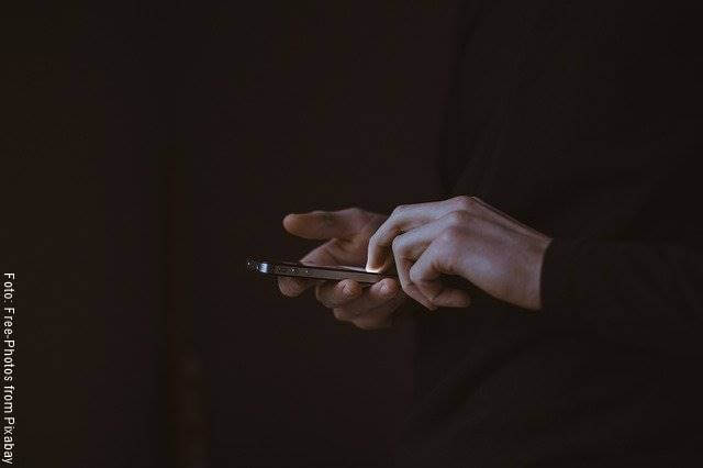 Foto de las manos de un hombre con un celular