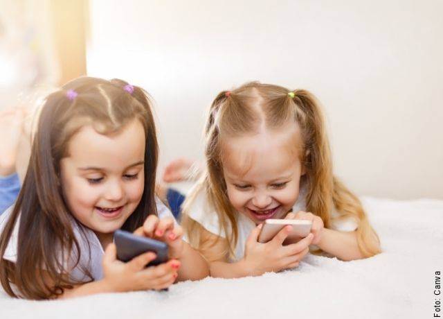 Foto de dos niñas usando celulares