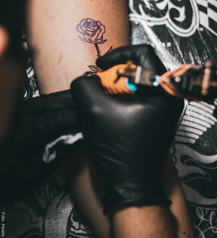 Hombre tatuando una rosa