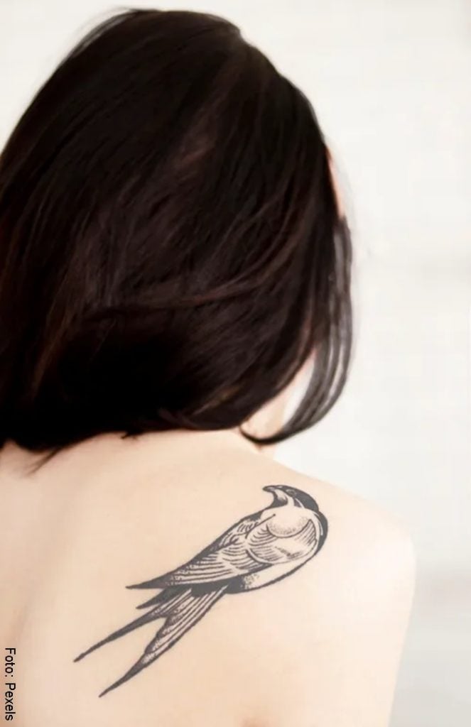 Mujer con tatuaje de un ave en la espalda