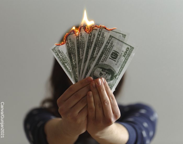 Foto de mujer sosteniendo billetes quemados en sus manos