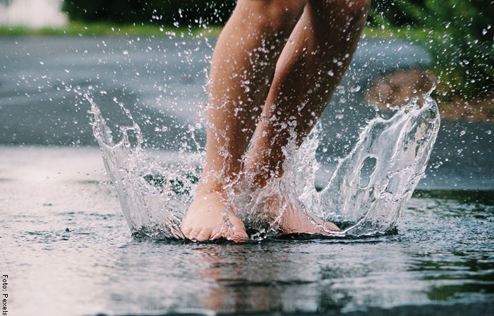 Foto de una persona saltando al agua descalza