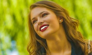 Foto de una mujer rubia sonriente que muestra el cuidado dental