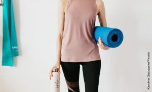 Foto de mujer sosteniendo un mat de yoga