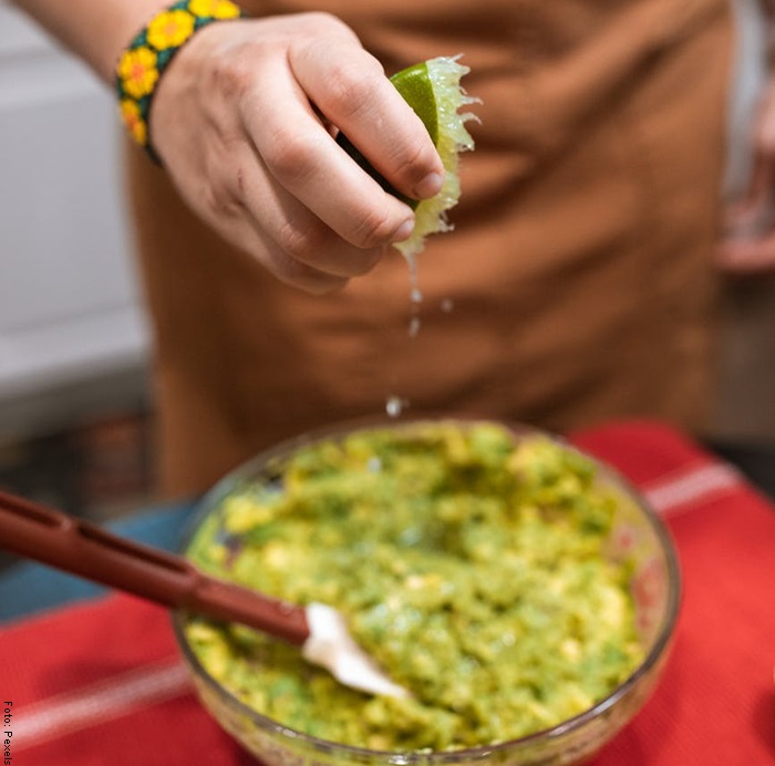 Foto de un hombre espichando un limón para ilustrar guacamole receta