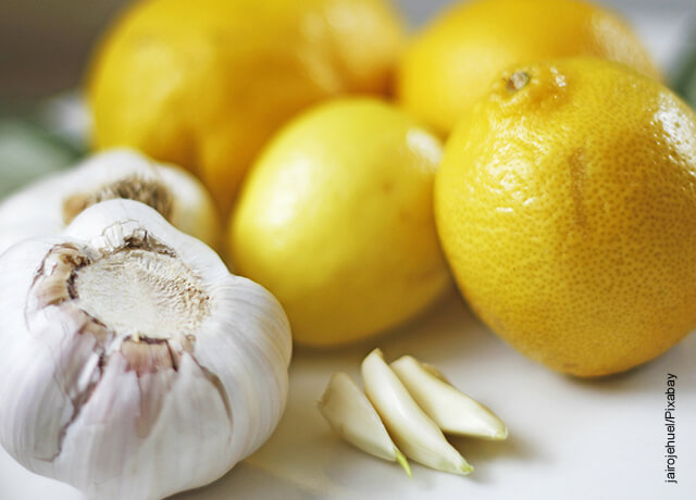 Foto de una cabeza de ajo junto a unos limones que muestran para qué sirve el ajo