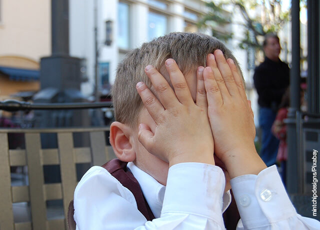 Foto de niño tapándose la cara de vergüenza