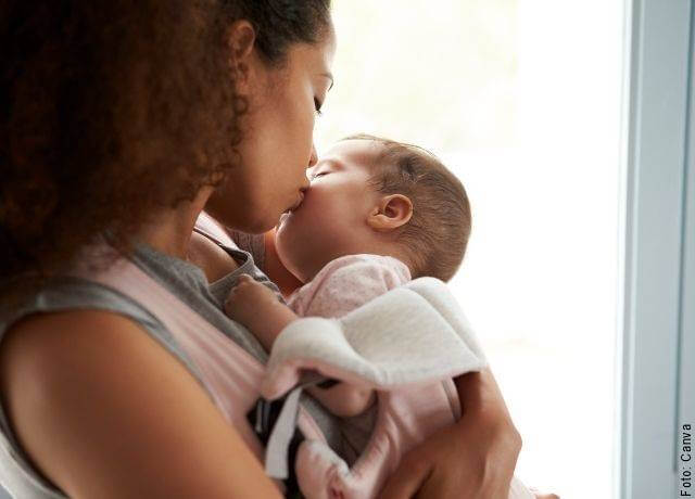 Foto de una madre besando a su bebé