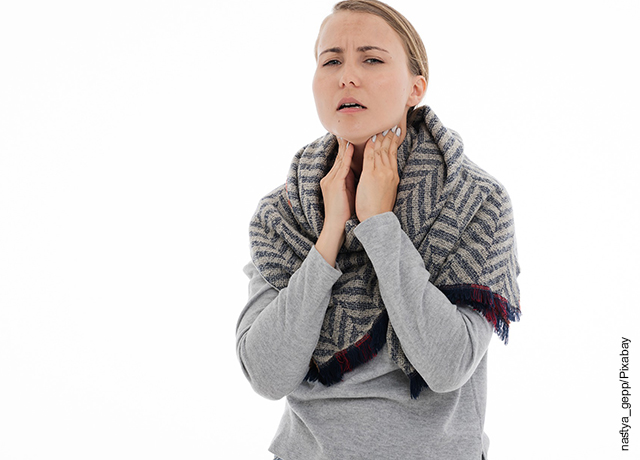 Foto de una mujer tomándose con dolor la garganta