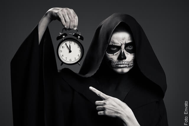 foto de calavera sosteniendo un reloj tiempo