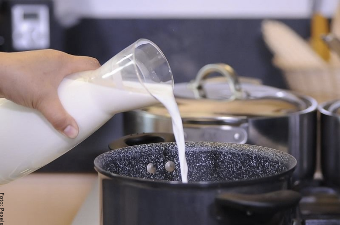 Foto de una persona poniendo leche en una olla para ilustrar cómo hacer crema pastelera