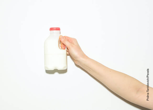 Foto de una mujer sosteniendo una botella de leche