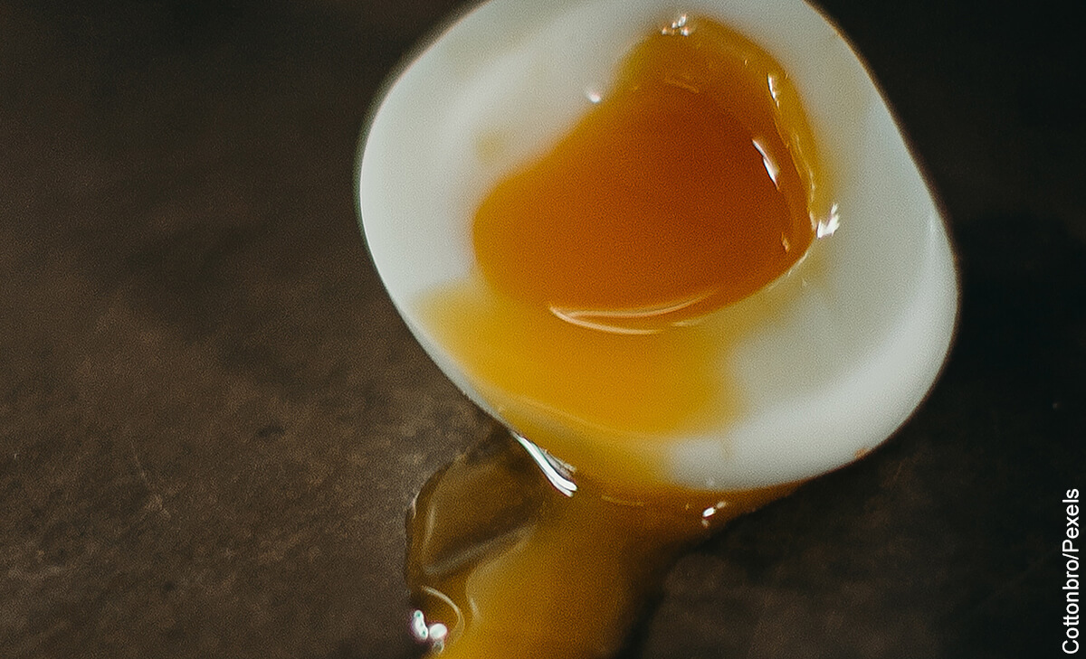 Foto de un huevo tibio abierto sobre una mesa