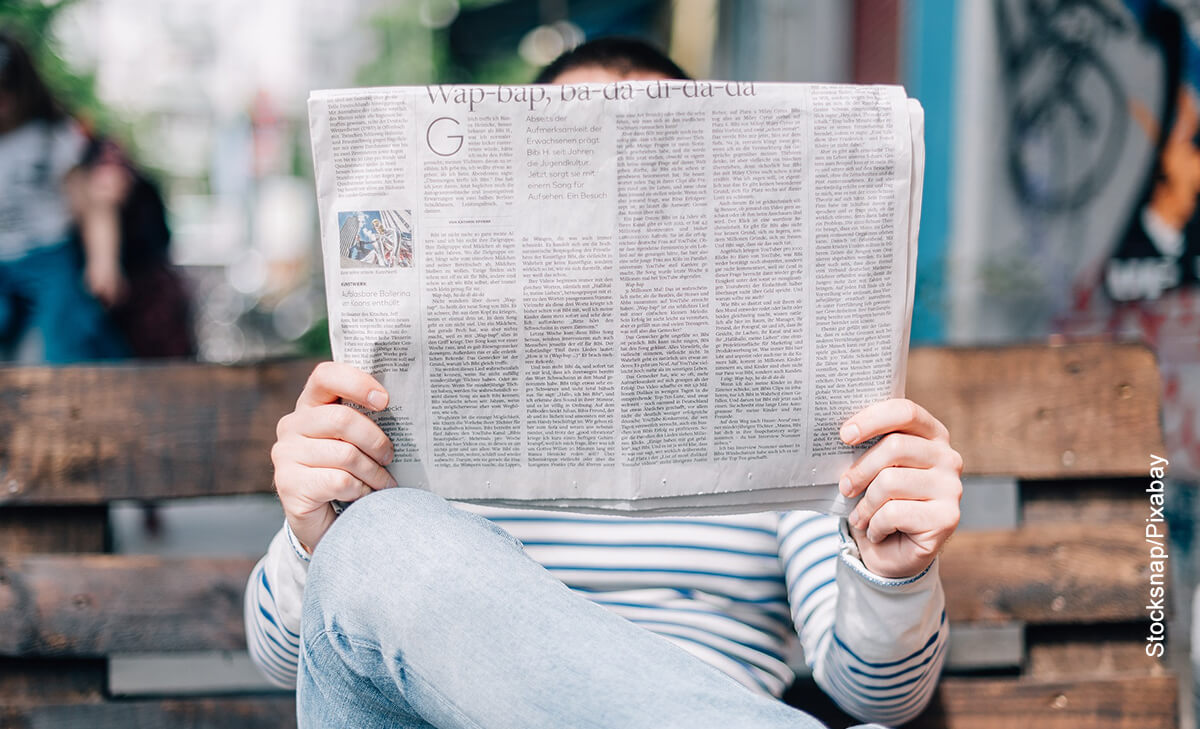 Foto de un hombre sentado leyendo un periódico
