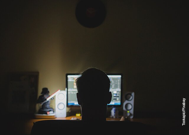 Foto de un hombre sentado frente a su computador trabajando que muestra cómo hacer una portada con normas APA