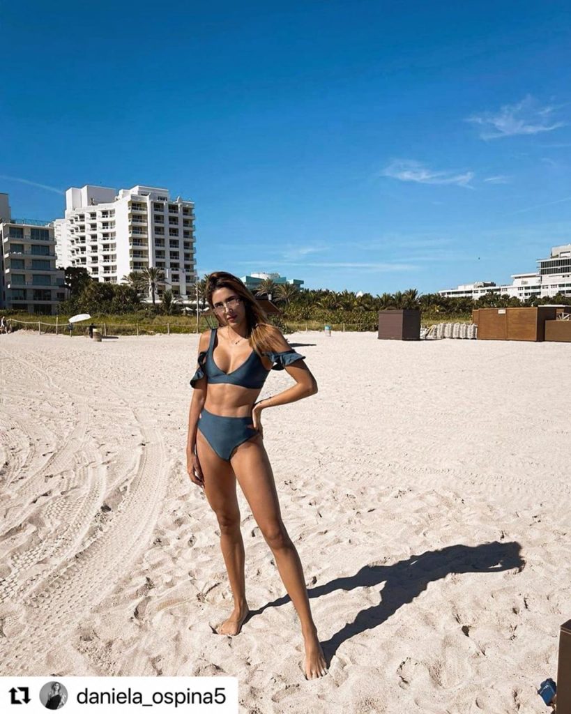 Daniela Ospina de cuerpo completo posando en traje de baño en la playa.