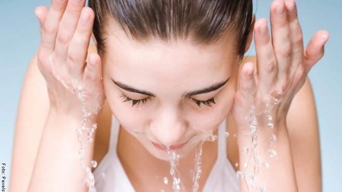 Foto de una mujer lavándose la cara