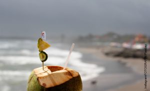 Foto de una bebida exótica en la playa que muestra para qué sirve el agua de coco