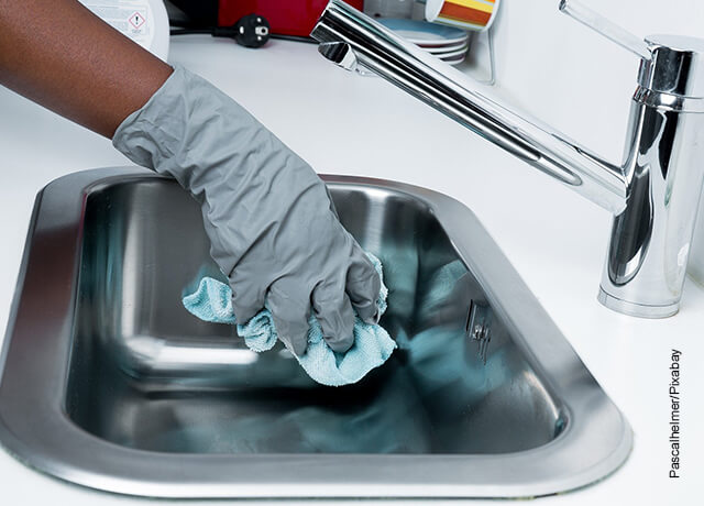 Foto de una persona lavando un lavaplatos