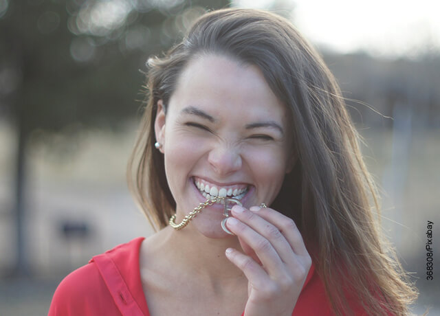Foto de una mujer sonriente mordiendo una medalla