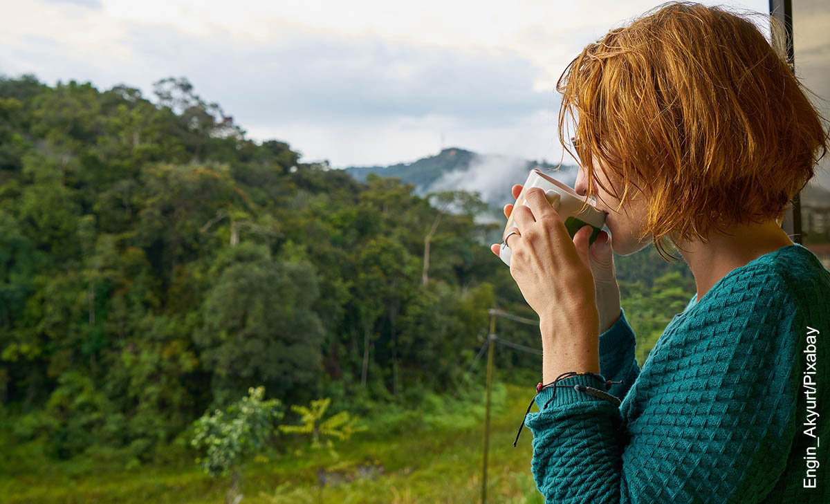 Foto de una mujer bebiendo de una taza al aire libre que ilustra el carbonato de calcio para qué sirve