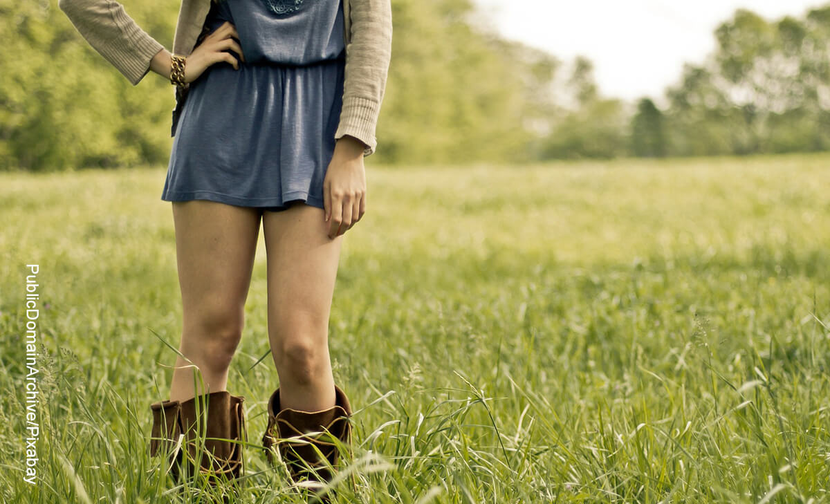Foto de las piernas de una mujer que está parada en un campo