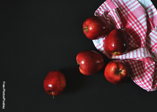 Foto de 5 manzanas rojas sobre una mesa negra
