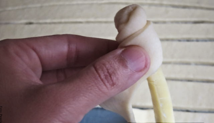 Foto de una persona envolviendo los dedos de queso