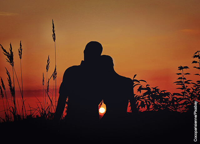 Foto de una pareja abrazada viendo el atardecer
