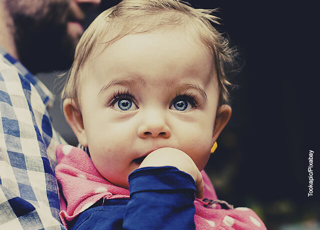 Foto de una bebé metiendo su mano a la boca que ilustra los nombres de niña
