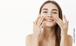 Foto de una mujer tocándose el rostro que muestra para qué sirve el ácido hialurónico